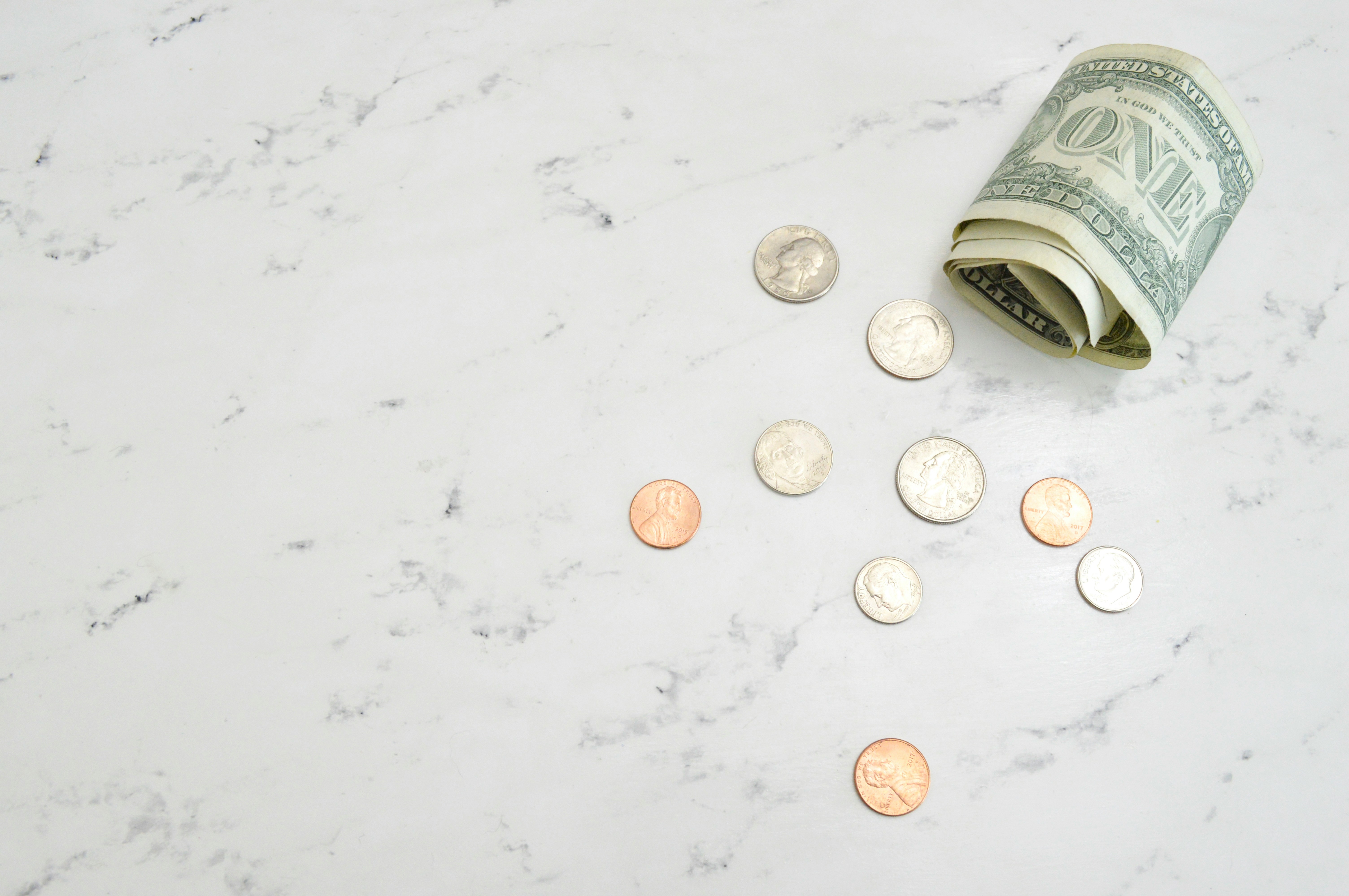 Coins and dollar on a table to illustrate cash flow management for nonprofits
