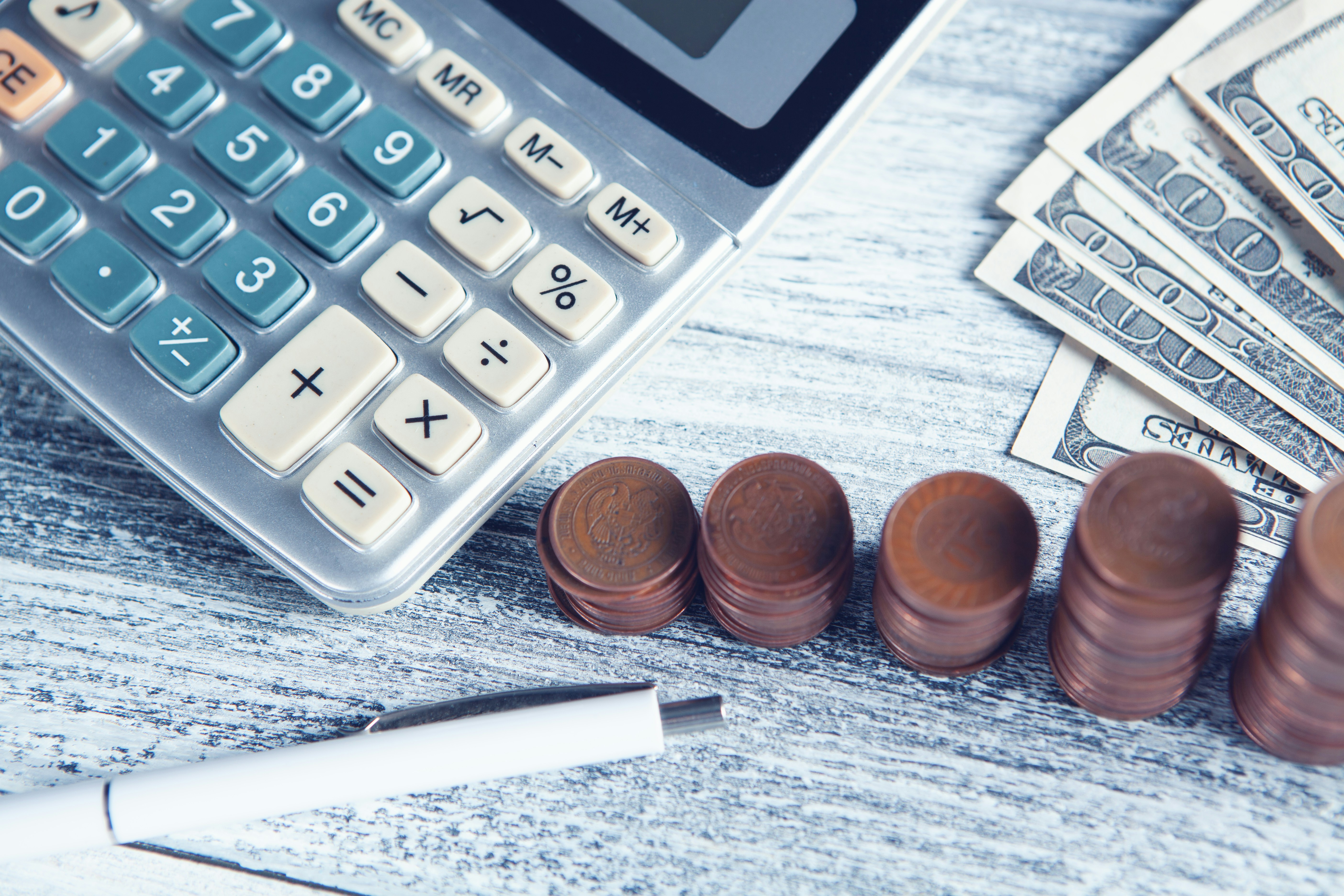 Calculator, pennies, and dollars to represent a federal grant budget